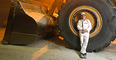 Man in front of a tractor tire - BOGE compressors for various industries